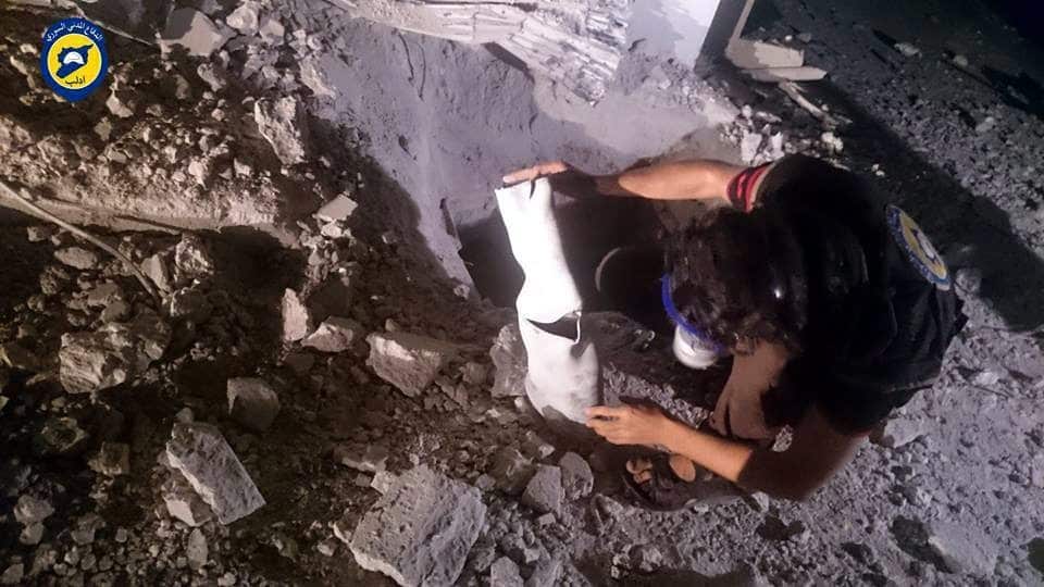 A handout picture made available by the Syria Civil Defense Idlib branch shows a man inspecting an object claimed to be a chlorine gas canister.