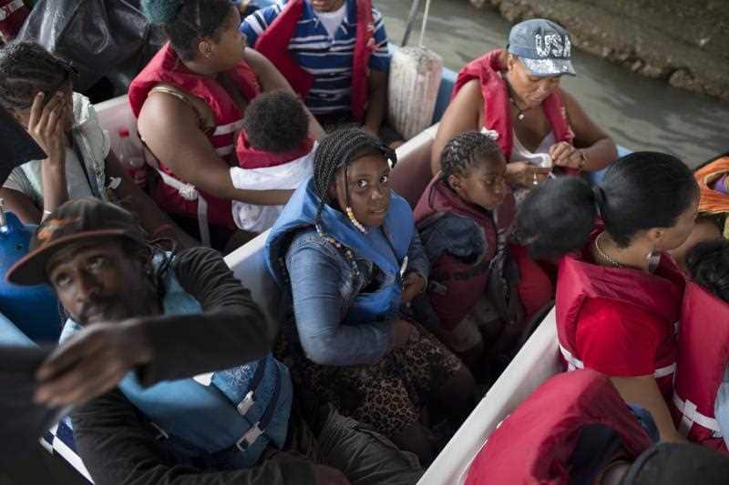 Passengers depart aboard a motor boat transport for the coastal town of Livingston before the arrival of Tropical Storm Earl