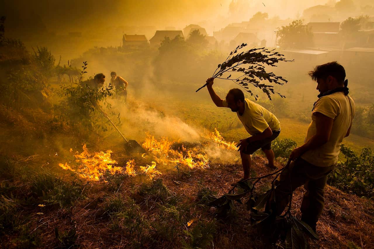 Neighbours fight a fire which began at Soutomayor village in Pontevedra, northwestern Spain, 10 August 2016, closes to the Spanish border with Portugal.