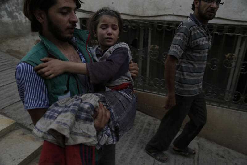 Abdulmonam Eassa's photo of a rescue worker carrying a girl in Eastern Ghouta.