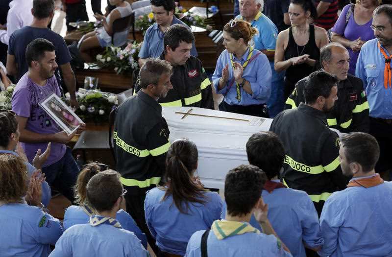 The coffin of 9-year-old Giulia Rinaldo, is carried outside the gymnasium at the end of the state funeral service in Ascoli Piceno, Italy