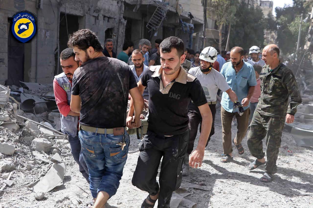 Rescue workers work the site of airstrikes in al-Mashhad neighborhood in the rebel-held part of eastern Aleppo, Wednesday Sept. 21, 2016