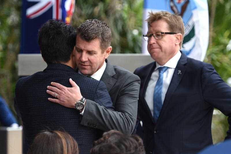 NSW Premier Mike Baird embraces Alpha Cheng, the son of Curtis Cheng, at a dedication ceremony at NSW Police headquarters in Sydney