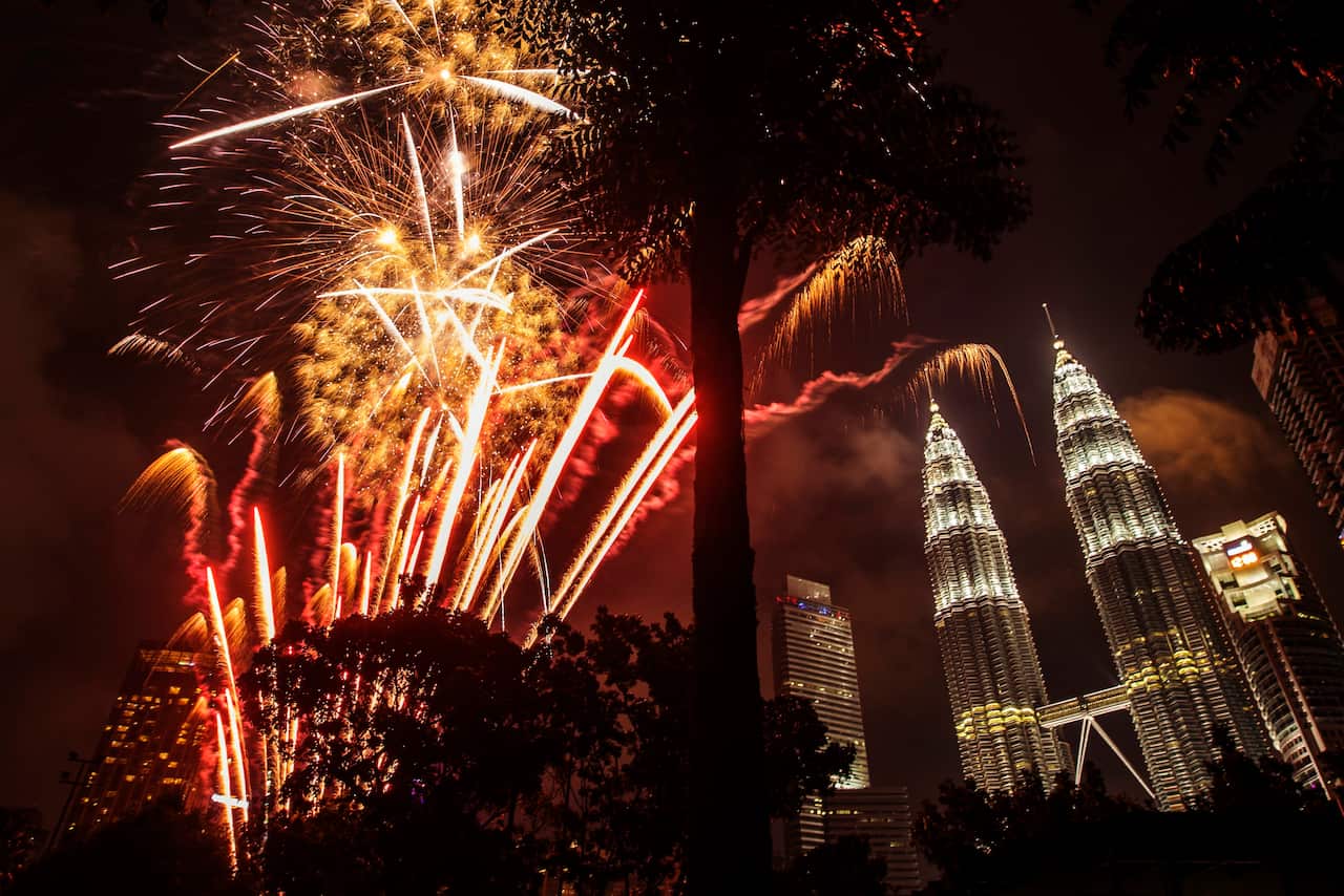 Fireworks illuminate the night sky over Malaysia's landmark, Petronas Towers during New Year's Eve celebrations in Kuala Lumpur