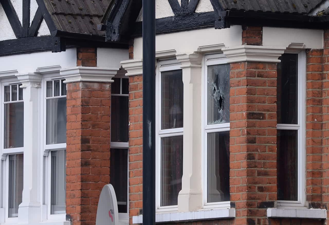 A shattered window at the scene in Harlesden Road, London, after a woman in her twenties was shot by police and four people arrested during terror raids.