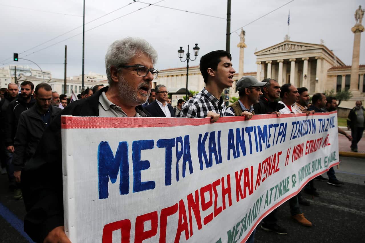 Protesters of the Communist-affiliated trade union PAME hold a banner and shout slogans during a protest at a 24-hour general strike, in Athens