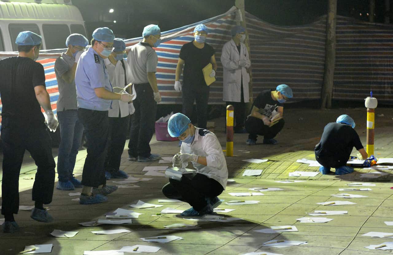Police officers examine the entrance to a kindergarten in Xuzhou in Jiangsu Province, eastern China 