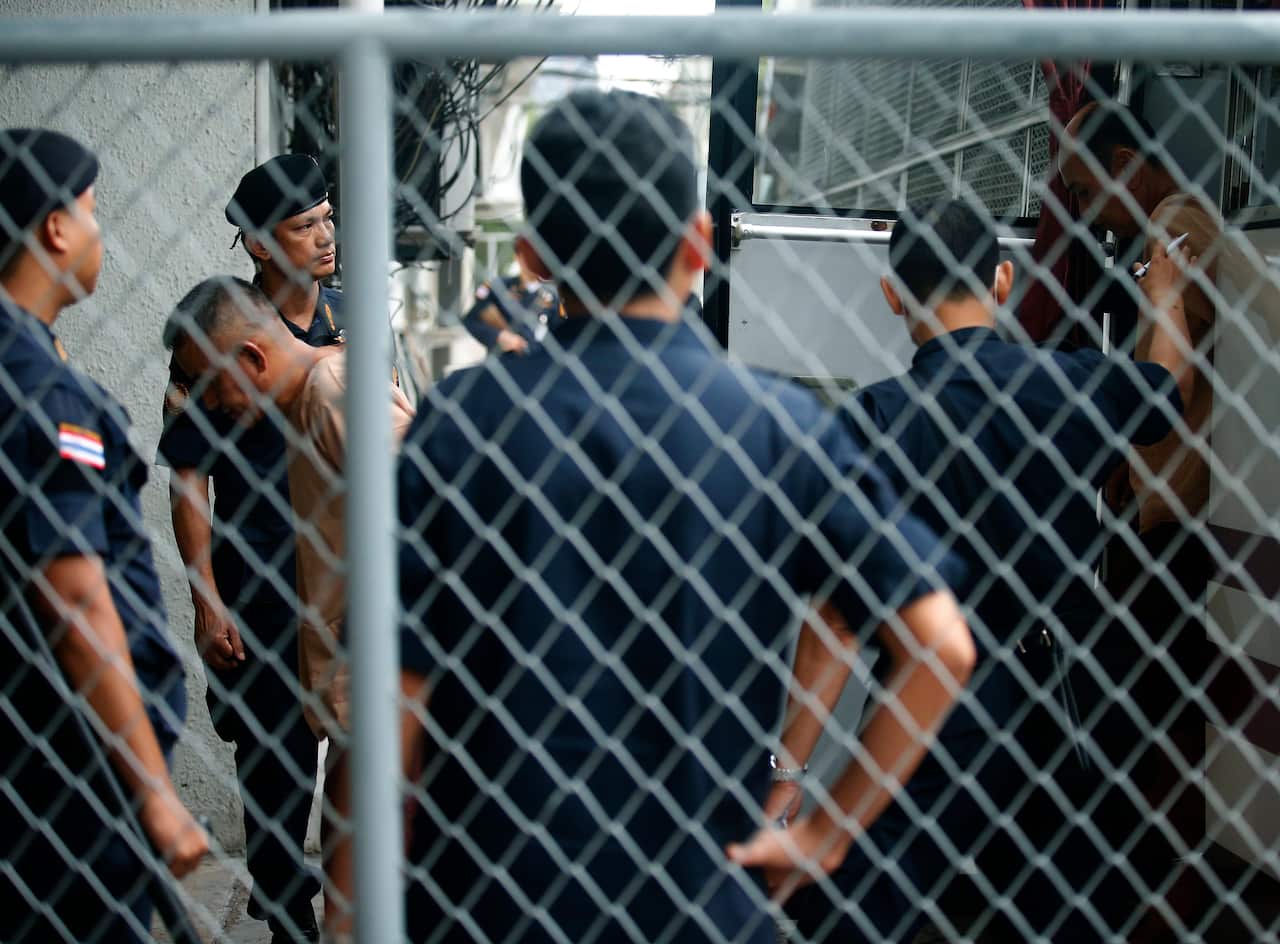 Thai police stand guard as suspects in a human trafficking case arrive at a Bangkok court on 19 July 2017.