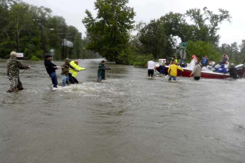 Volunteers help pull a rescue boat in from sweeping currents in floodwaters in the aftermath of Harvey in Beaumont, Texas on Wednesday, Aug. 30, 2017.