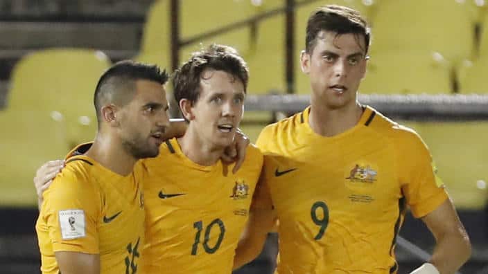 Aziz Behich, Robbie Kruse and Tomi Juric celebrate Australia's opening goal against Syria. 