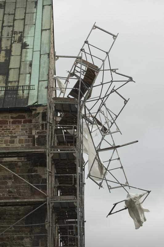 A scaffolding hangs off the facade of a monastery in Magdeburg, Germany, Thursday, Oct. 5, 2017. Storm Xavier brought strong winds to northern Germany. 