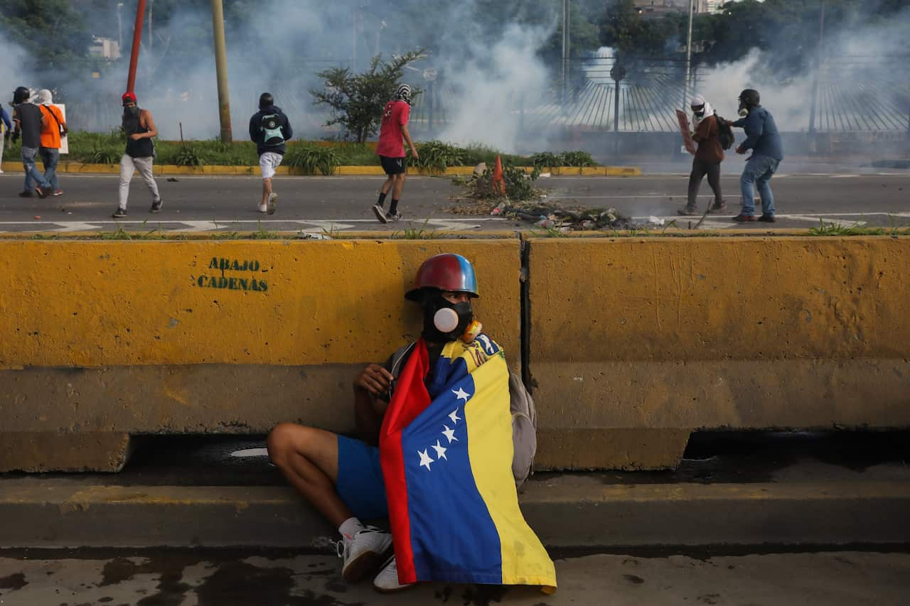 A protester hides behind a wall during protests in Caracas, Venezuela in June 2017. 