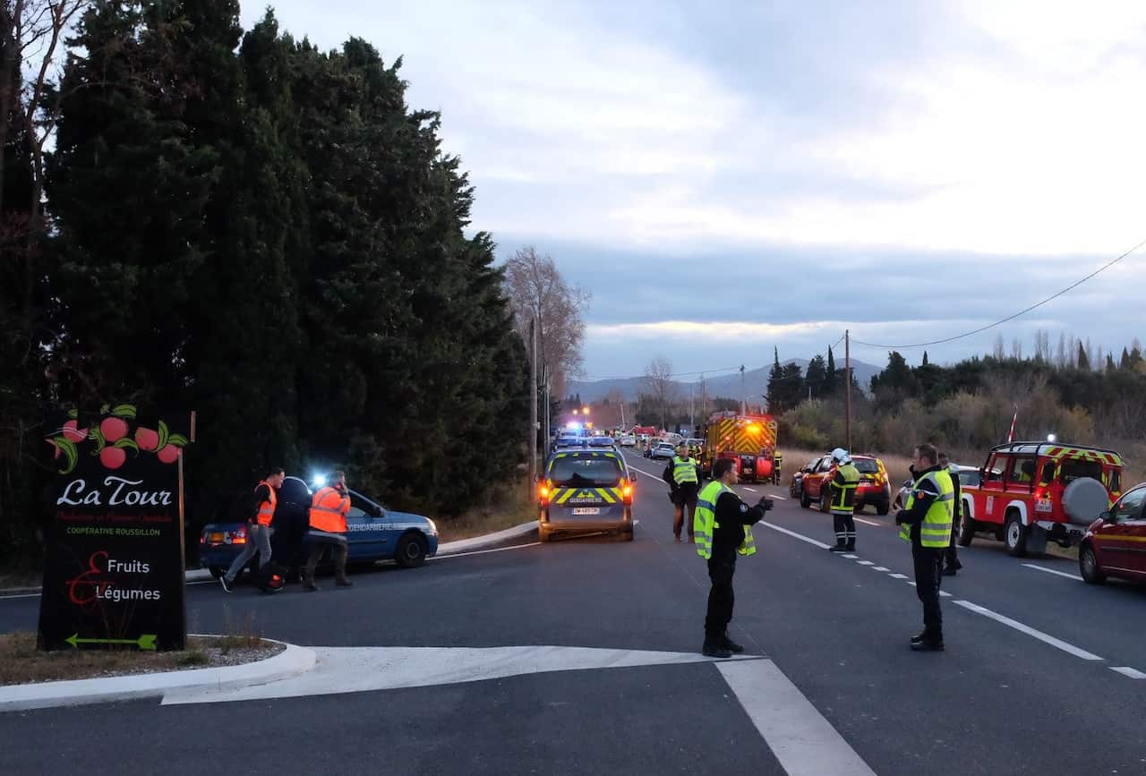 Emergency personnel secure a perimeter near a crash site of a school bus with a train near Millas and Saint-Feliu-d'Amont, Southern France, 14 December 2017.