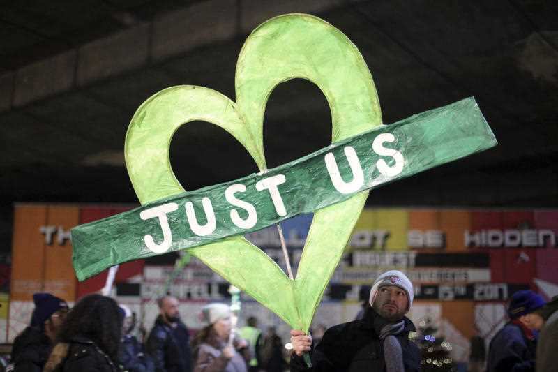 A man holds a banner declaring that the victims are on their own without help from the authorities, during a silent walk to mark the six month anniversary of the Grenfell Tower fire, near to the site of the fatal apartment building blaze in west London.