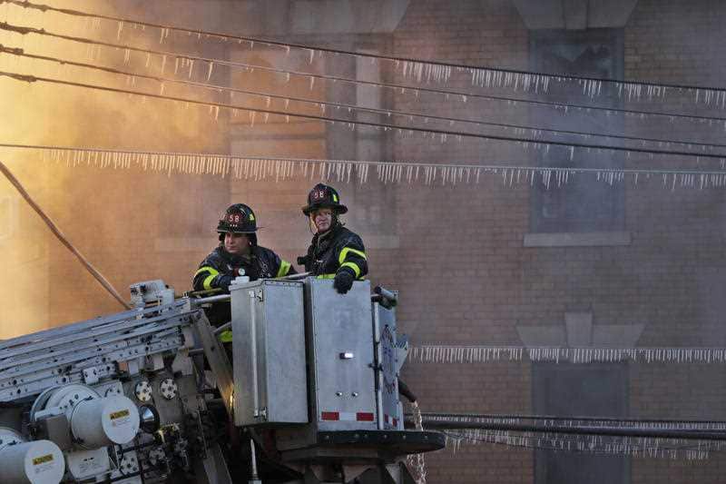 Firefighters work to contain a blaze at a building in the Bronx section of New York, Tuesday, Jan. 2, 2018.