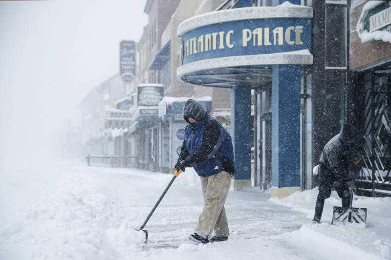 Workers clear the boardwalk during a winter snowstorm in Atlantic City, N.J., Thursday, January 4, 2018.