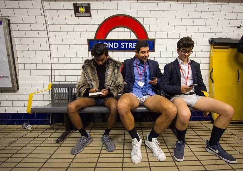 People wait on the platform at Bond Street tube station as they take part in No Trousers on the Tube day, in London.