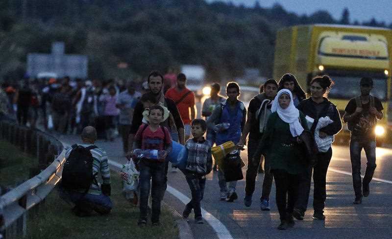 People walk in a long line along the highway near Budapest, Hungary, 