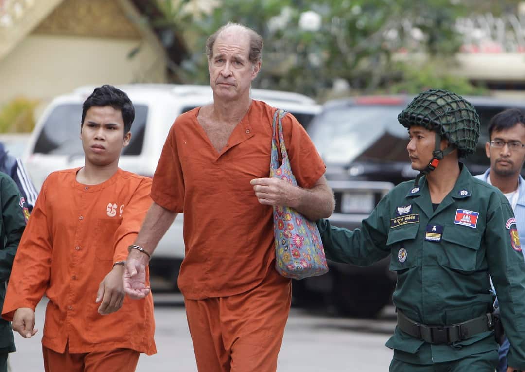 Australian filmmaker James Ricketson is escorted by prison guards.