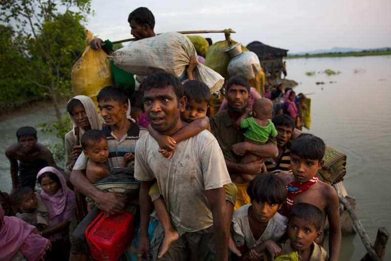 Rohingya Muslims carry their young children and belongings after crossing the border from Myanmar into Bangladesh.