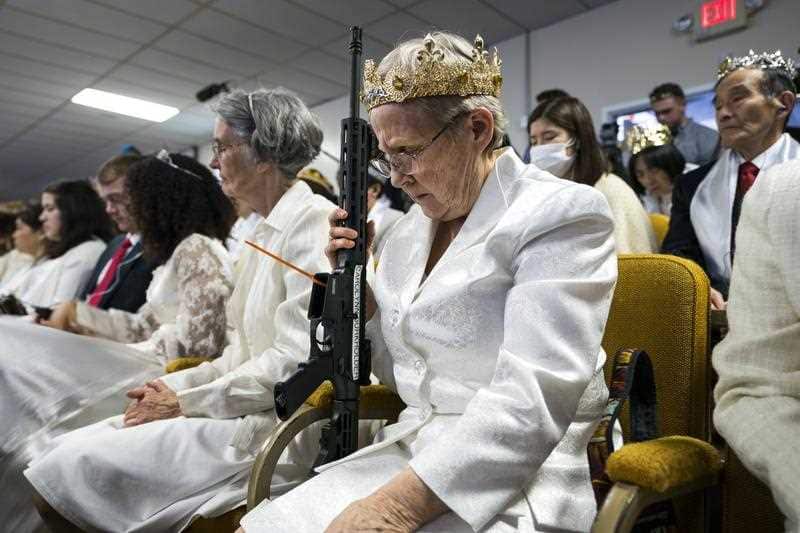A parishioner with the Sanctuary Church holds onto her AR-15, which churchgoers were encouraged to bring to a blessing ceremony to rededicate their marriages