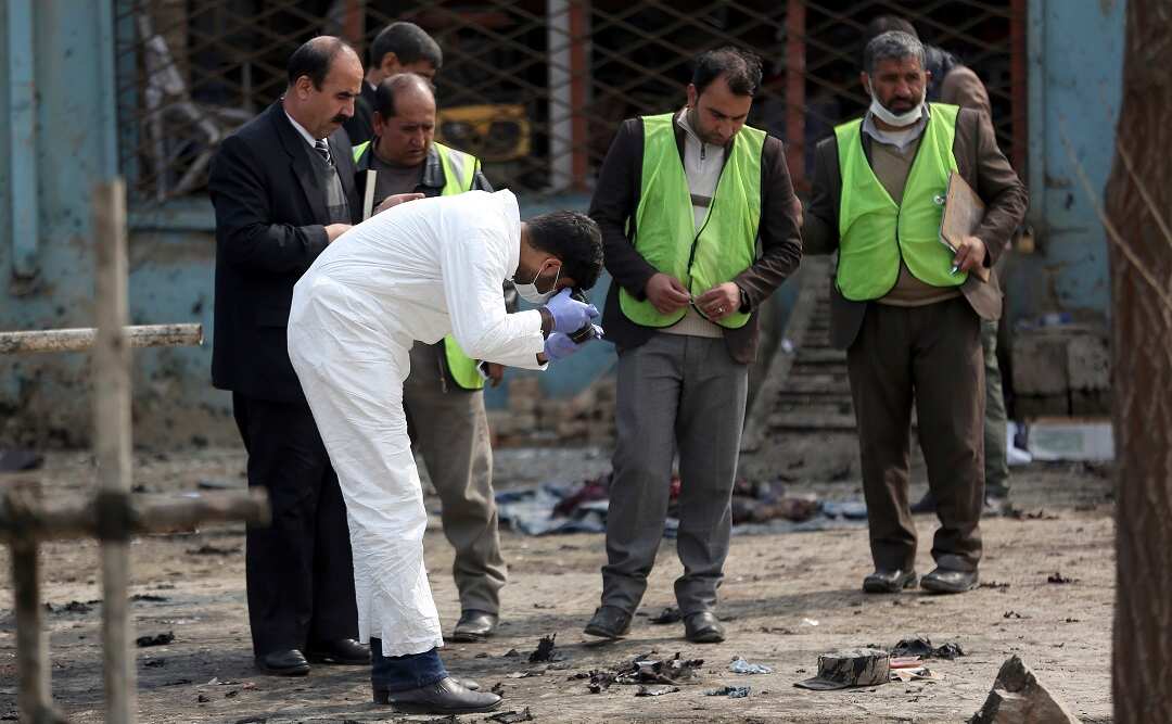 Security personnel inspect the site of the suicide attack.