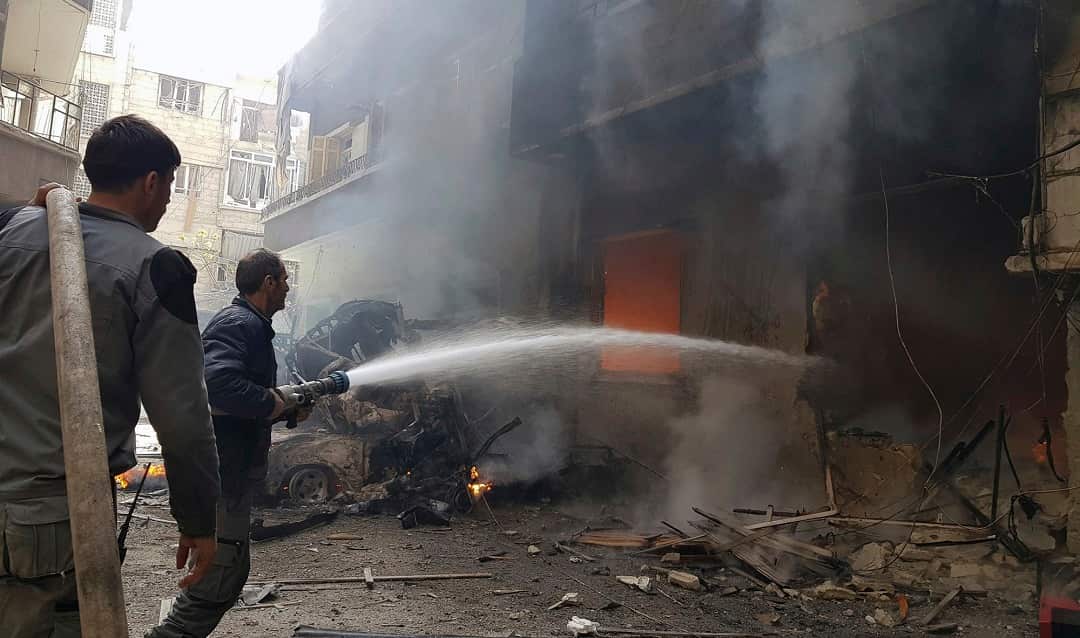 Civil Defense workers put out a fire following airstrikes and shelling in Douma.