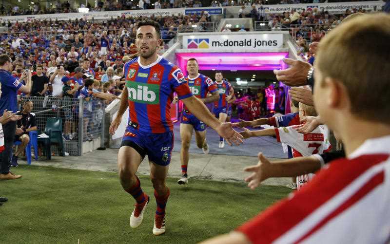 Brock Lamb running out in a Newcastle Knights jersey.