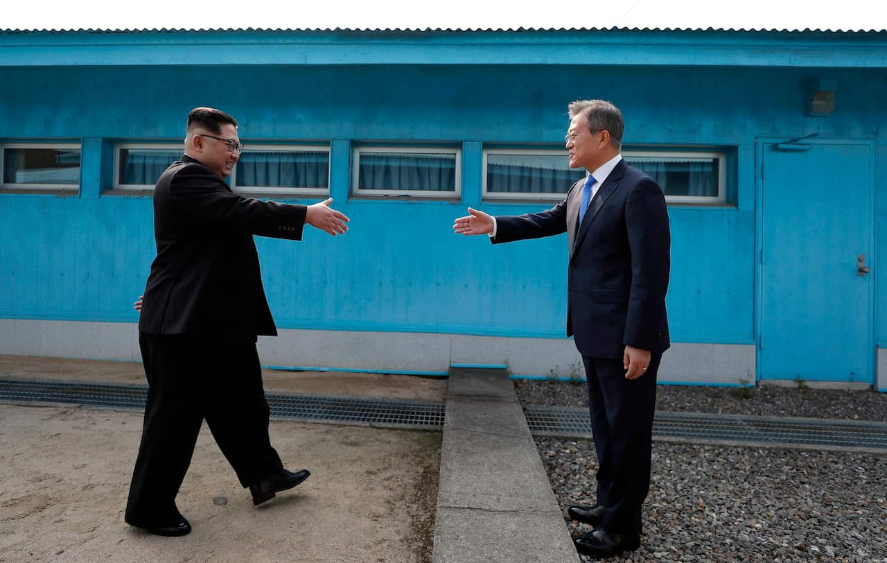 North Korean leader Kim Jong-un shakes hands with South Korean President Moon Jae-in between the military demarcation line.