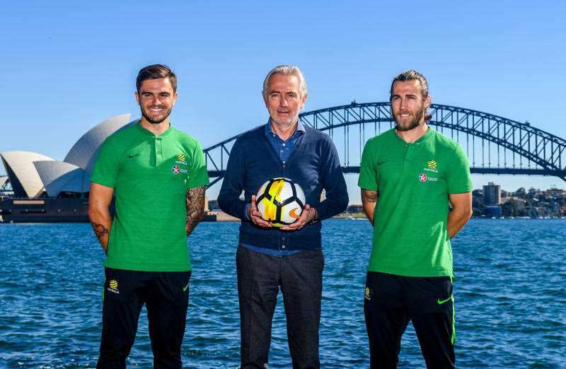 Socceroos Head Coach Bert van Marwijk (centre) with Midfielder Josh Brillante (right) and defender Josh Risdon pose for a photograph on Sydney Harbour in Sydney, Monday, May 7, 2018.