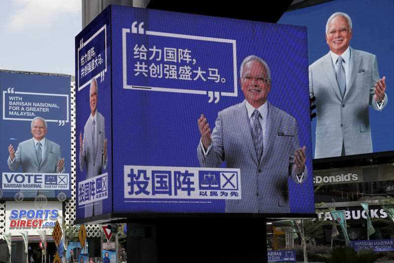 Electronic display panels advertising images of Malaysian Prime Minister Najib Razak and his ruling National Front coalition on display at a popular shopping district in Kuala Lumpur, Malaysia, Monday, May 7, 2018.