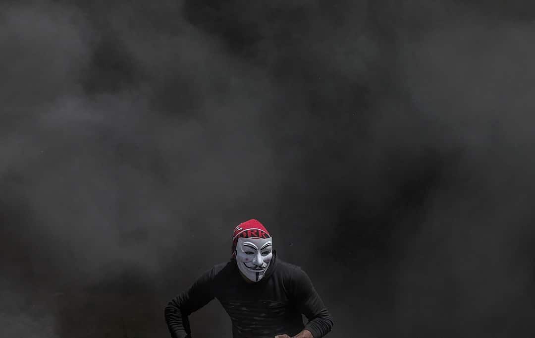 A Palestinian protester wearing a Guy Fawkes mask.