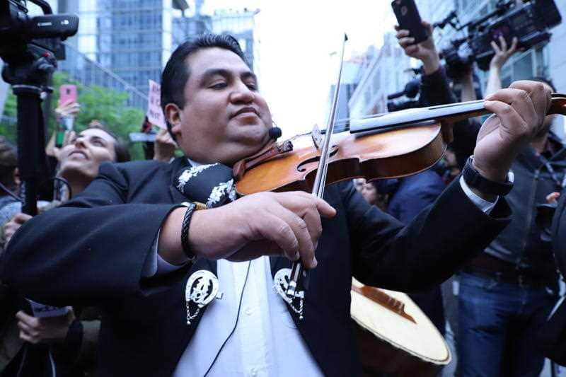 A mariachi band plays as demonstrators gather for a "Latin Party" and protest outside the Manhattan apartment of Aaron Schlossberg in New York City.