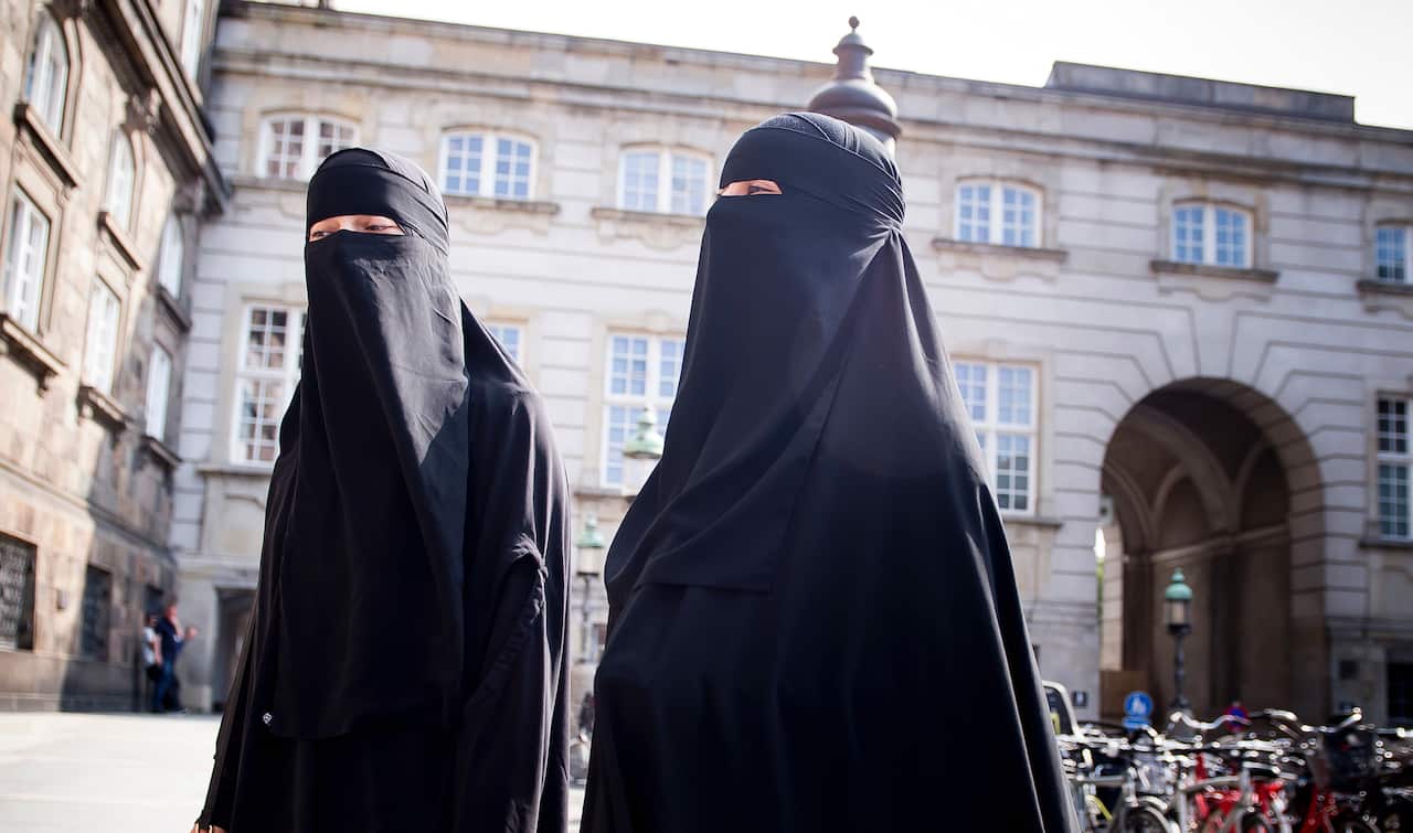 Women in niqab walk, in front of the Danish Parliament at Christiansborg Castle, in Copenhagen, Denmark, Thursday May 31. 2018.