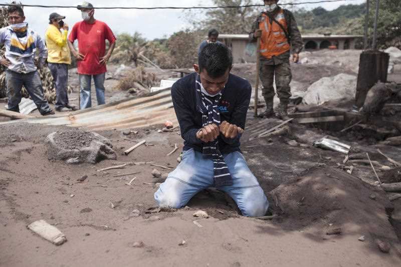 Bryan Rivera cries after looking at the remains of his house, after his family went missing during the Volcan de Fuego or "Volcano of Fire" eruption. 