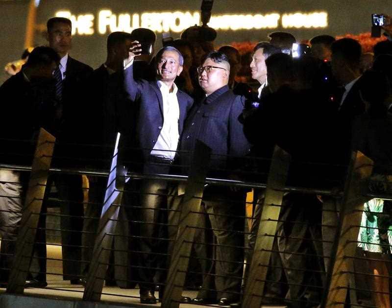 North Korean leader Kim Jong-un (C-R) and Singapore Foreign Minister Vivian Balakrishnan (C-L) take selfies on the Jubilee bridge.