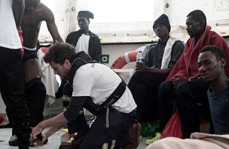 A handout photo made available by NGO 'SOS Mediterranee' shows volunteers and rescued migrants aboard the 'Aquarius' ship at sea in the Mediterranean.
