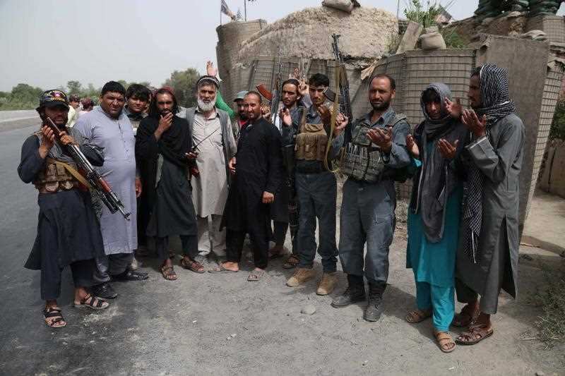 Alleged Taliban militants pose for a photograph with Afghan Police as a goodwill gesture amid the three-day ceasefire.