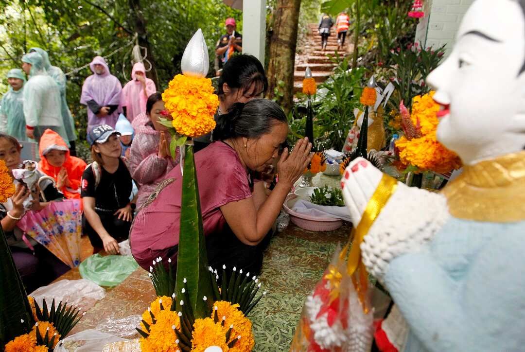 People pray at a shrine at the entrance of the cave.