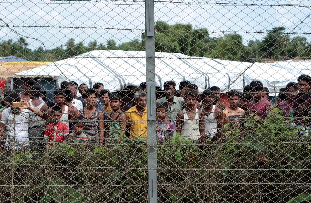 Rohingya refugees gather near the fence in the "no man's land" between Myanmar and Bangladesh.