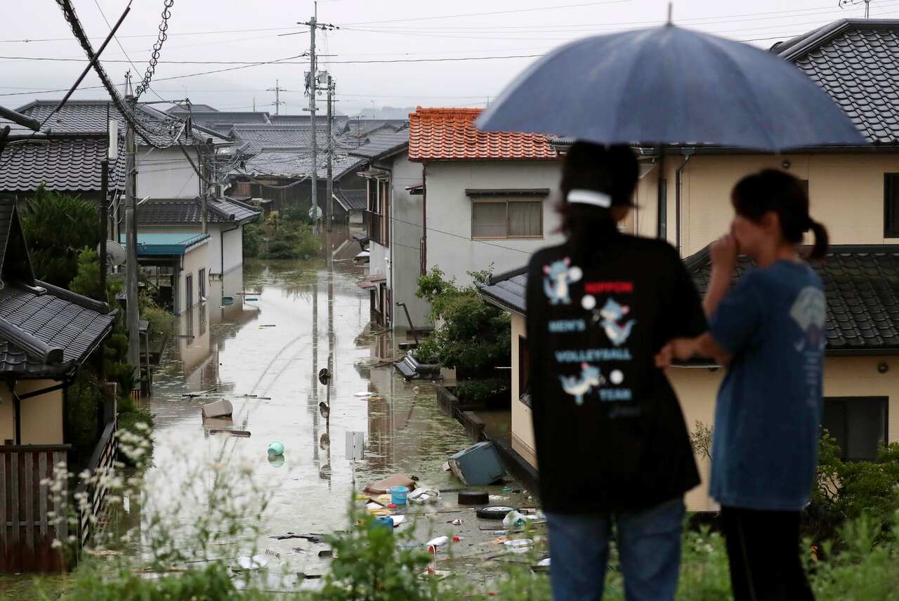 Residents look over their flooded town in Kurashiki, Okayama Prefecture, western Japan.
