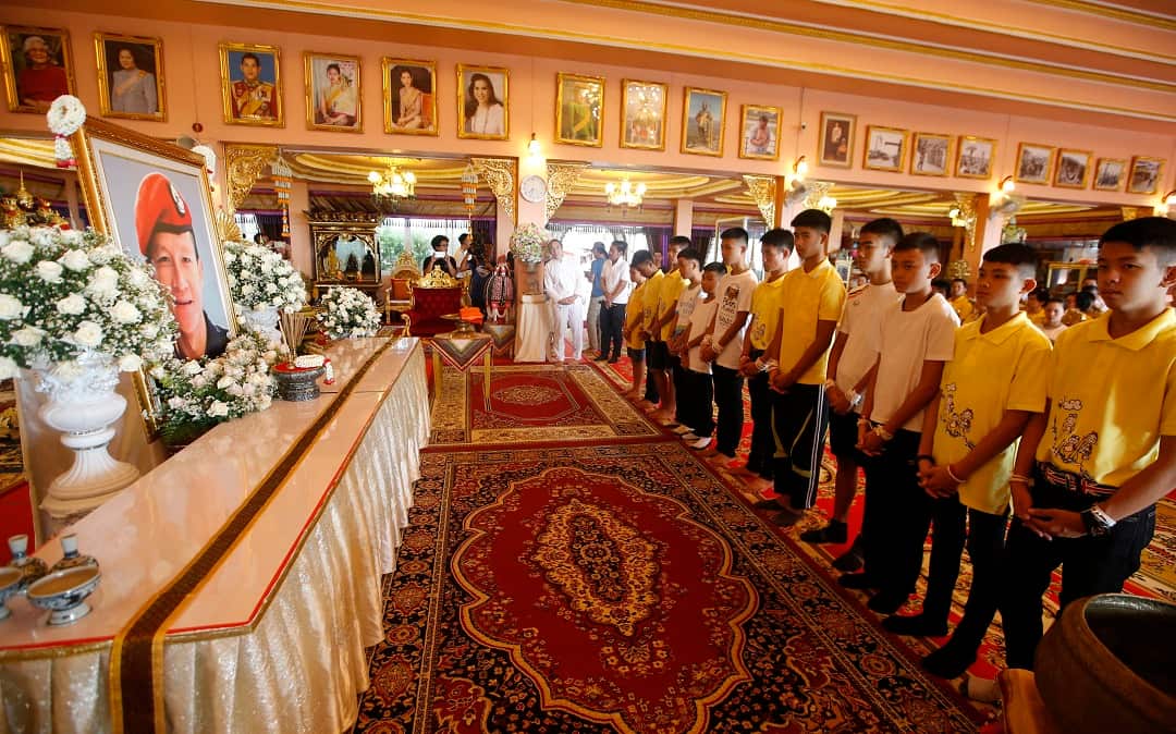 The boys pray in front a portrait of Saman Gunan, the retired Thai SEAL diver who died during their rescue attempt.