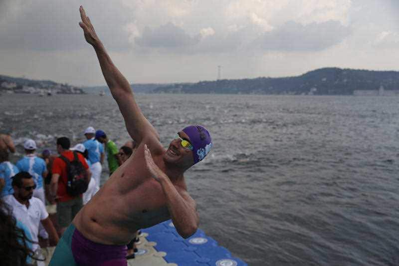 An athlete celebrates after he swam in the Bosporus Cross-Continental Swimming Race in Istanbul, Sunday, July 22, 2018.