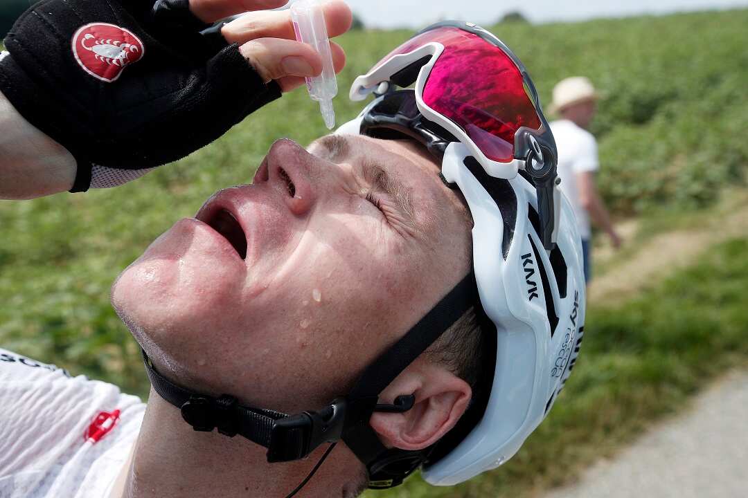 Team Sky rider Chris Froome of Britain cleans his eyes after tear gas was used by policemen against protesting farmers.