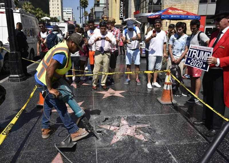 Workers remove the damaged remains of President Donald J. Trump's star on the Hollywood Walk of Fame after it was destroyed overnight in Hollywood section of Los Angeles, California, USA, 25 July 2018.