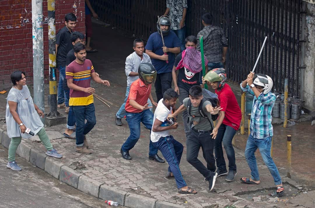 A photojournalist runs as a group of unidentified men attack him during the protests.