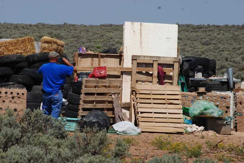 Taos County Solid Waste Department Director Edward Martinez surveys property conditions at a disheveled living compound at Amalia, N.M., Tuesday, Aug. 7, 2018.