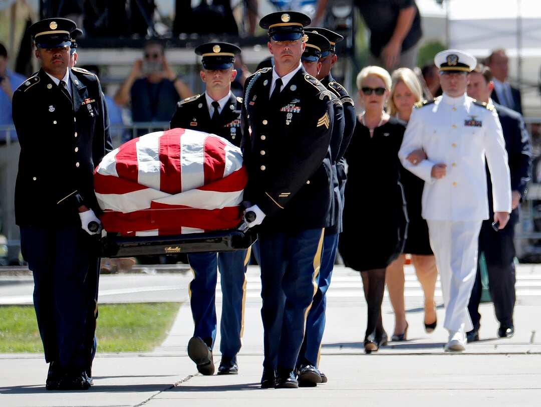 Military personal carry the casket of John McCain.