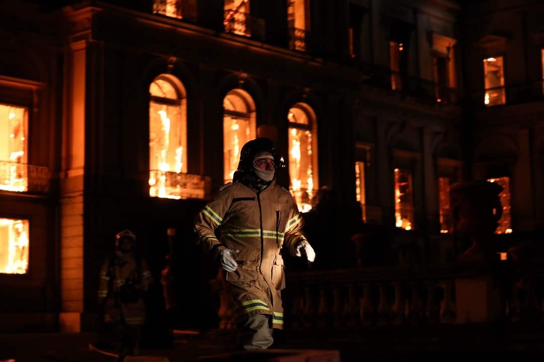A firefighter walks in front of the National Museum of Rio de Janeiro.