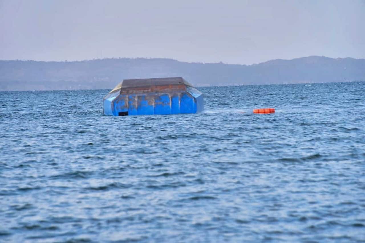 The upturned passenger ferry MV Nyerere floats in the water in Lake Victoria.